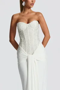 Detail of a white strapless corset dress with shimmering sequins and elegant draped skirt
