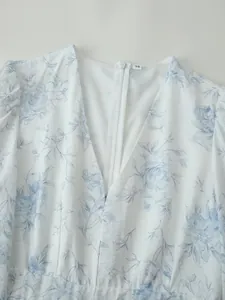 Dettaglio di un abito a fiori bianchi e blu con scollo a V e cerniera posteriore invisibile