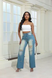 Full view of high-waist ripped washed denim jeans styled with a white crop top.
