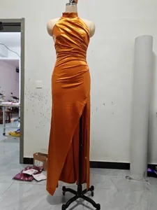 Full length display of an elegant orange halter-neck satin dress featuring high side slit