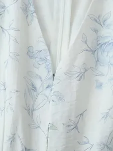 Vista macro dettagliata della cerniera e dello scollo a V su un abito a fiori blu e bianco