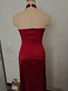 Detail view showing the back design of a burgundy halter neck slim fit evening dress.