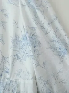 Primo piano del tessuto bianco con elegante stampa floreale blu per abito estivo