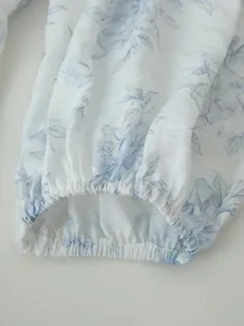 Dettaglio del polsino elasticizzato di un abito estivo con stampa floreale blu