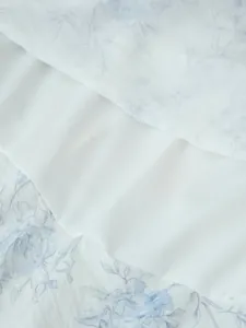 Dettaglio ravvicinato del tessuto con stampa floreale e fodera bianca di un abito.
