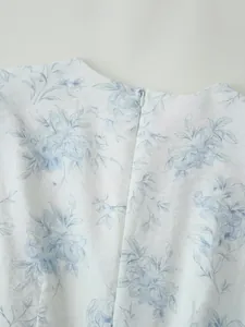 Vista dettagliata della cerniera nascosta e della stampa floreale blu su abito estivo