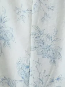 Primo piano di un'elegante stampa floreale blu su tessuto bianco per vestito estivo