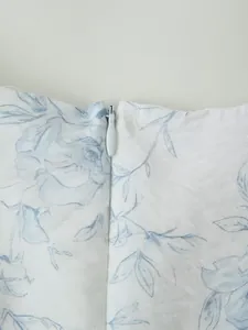 Dettaglio ravvicinato della cerniera invisibile su un abito bianco a fiori blu sottili