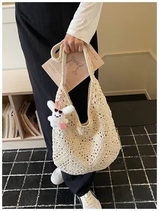 Vista dettagliata della borsa tote all'uncinetto bianco panna con motivi floreali