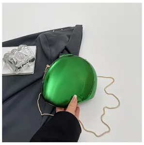 Primo piano di una borsa da sera verde metallizzato a forma di conchiglia
