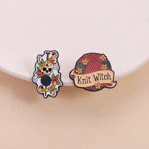 Dettaglio delle spille in smalto con motivi a gomitolo, teschio e scritta Knit Witch