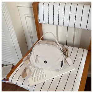 Bolso bandolera de nailon crema para mujer en un entorno de estilo de vida acogedor