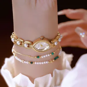 Dettaglio di un elegante orologio ovale Bee Sister dorato con cinturino di perle