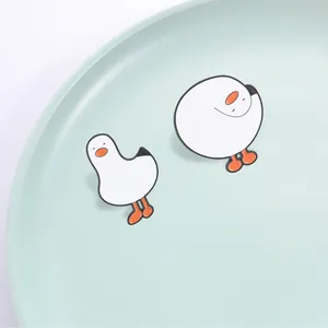 Paar schattige witte cartoon gans emaille pinnen op een prachtig licht mintgroen bord
