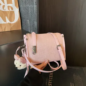 Close-up of pink textured pillow bag featuring a cute plush bear charm decoration