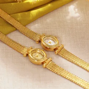 Detalle de un elegante reloj de joyería vintage dorado con correa de malla de espiga