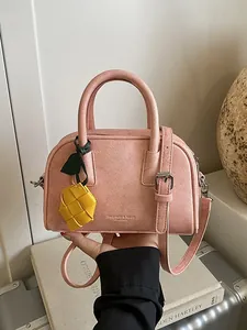 Elegant pink textured leather pillow handbag with stylish yellow woven charm for women