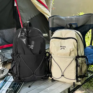 Deux sacs à dos de camping Norvincy en noir et beige sur une table de camping.