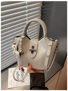 Détail d'un sac seau en cuir gris clair avec ferrures argentées et charm cheval