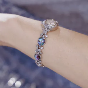 Primer plano de un elegante reloj de pulsera para mujer con concha de abulón natural