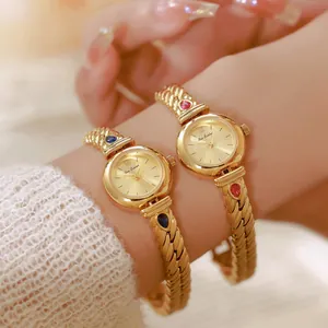 Primer plano de relojes vintage dorados con elegantes correas de circonitas rojas y azules