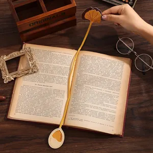 Detail view of a vintage gold metal flower bookmark tucked into an antique book