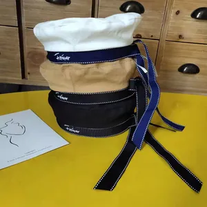 Stack of three beret hats in white, khaki, and black with long ribbons and Forever embroidery
