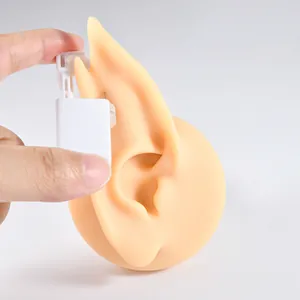 Detail shot of flesh-colored silicone elf ear model for piercing jewelry display