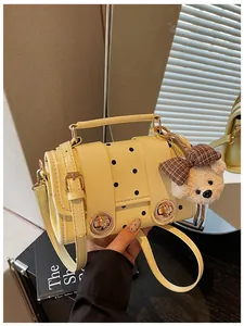 Detailed shot of a vintage yellow polka dot crossbody bag with a cute plush bear charm accessory