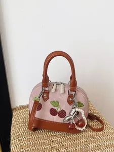 Elegante bolso bandolera rosa pequeño con bordado de cerezas y llavero decorativo de perlas