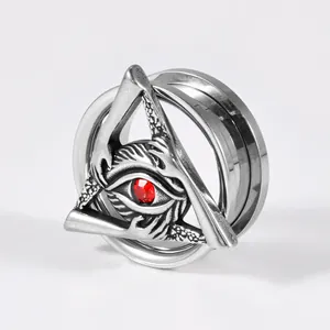 Detailed macro view of a stainless steel ear gauge featuring a red evil eye in a triangle.
