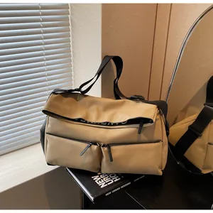 Detail view of khaki multi-pocket crossbody bag showing zippers and durable nylon material