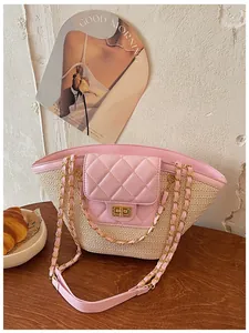 Vue détaillée d'un sac cabas en paille tissée avec rabat rose et chaînes dorées