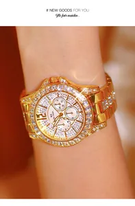 Close-up of a luxurious gold women's watch encrusted with sparkling rhinestones on a wrist