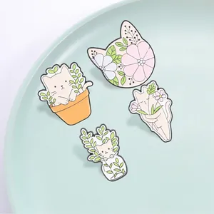 Set of four cute cartoon cat enamel pins featuring floral and plant motifs for accessories