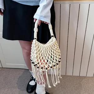Handmade macrame woven tote bag featuring fringe accents and decorative wooden bead details