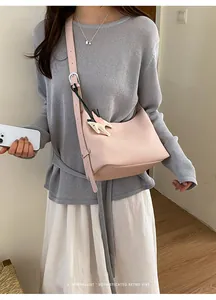 Pink leather hobo shoulder bag detail shot, minimalist retro style everyday carry accessory.