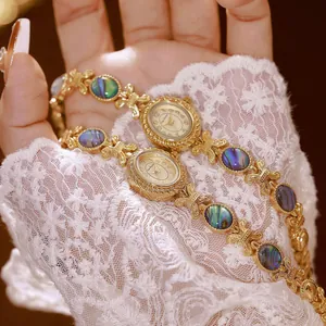 Detalle macro del reloj de pulsera dorado vintage Bee Sister con nácar de abulón natural