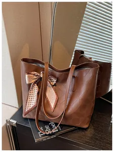Stylish large brown tote bag with geometric diamond pattern and decorative scarf