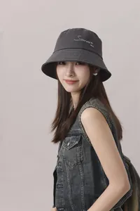 Primer plano de un elegante sombrero de pescador gris con bordado usado por una modelo