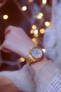 Elegant gold-plated women's watch with rainbow crystal bezel and iced out dial