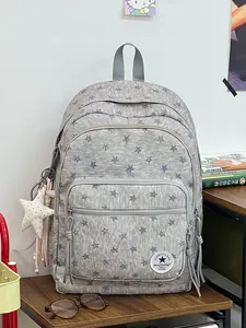 Front view of grey star pattern backpack with white star charm and logo patch