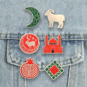Colección de pines de esmalte exóticos con luna, cordero y mezquita en una chaqueta denim.