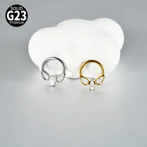 Detail van zilveren en gouden G23 titanium septumringen met druppelvormige zirkoon