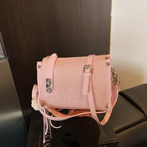 Close-up detail of a pink textured fabric pillow bag with silver hardware accents.