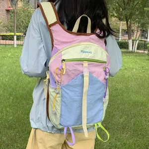 Rear view of a multi-colored outdoor hiking backpack worn by a model in a green park.