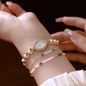 Primo piano dettagliato di un orologio da donna in oro vintage con cinturino in perle sul polso