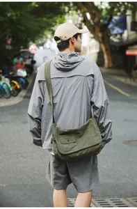 Detailed back view of a large olive green canvas messenger bag for casual outdoor use