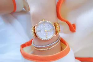 Primer plano de reloj dorado BS para mujer con esfera de diamantes y pulseras a juego