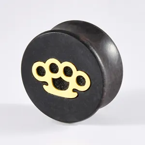 Close-up macro view of ebony wood ear gauge with golden brass knuckle metal inlay
